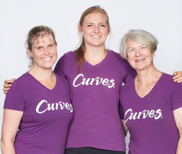 Three women wearing Curves t-shirts