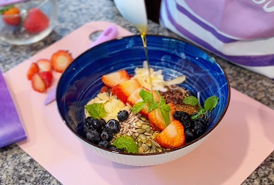 A nutritious breakfast bowl filled with Greek yogurt, fresh strawberries, blueberries, seeds, mint, and a drizzle of raw honey. Recipe from the Curves Pure 30 Challenge